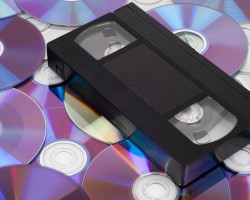 CD vs VHS. VHS cassette lay on the many CD disks